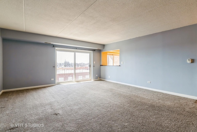 carpeted empty room featuring baseboards and a textured ceiling