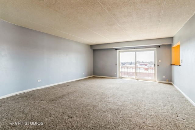 carpeted empty room featuring baseboards and a textured ceiling