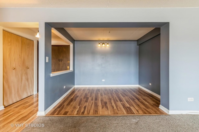 empty room with baseboards and wood finished floors