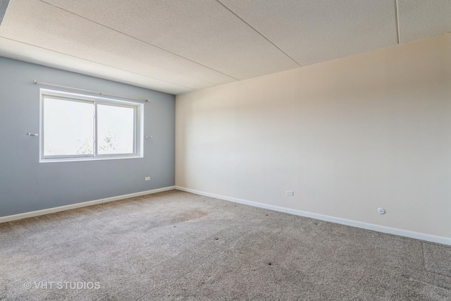 unfurnished room with carpet flooring, baseboards, and a textured ceiling