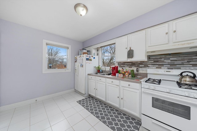 kitchen with light countertops, backsplash, white cabinetry, white appliances, and under cabinet range hood