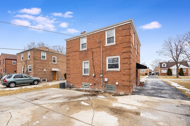 exterior space featuring central AC unit and brick siding