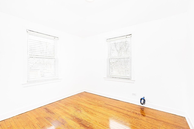 unfurnished room with baseboards and wood finished floors