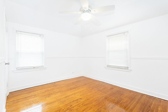 spare room featuring a ceiling fan, baseboards, and wood finished floors