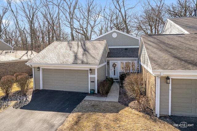 view of front of house with a garage and a shingled roof