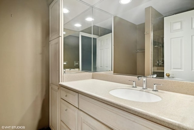 bathroom with recessed lighting, a shower, and vanity