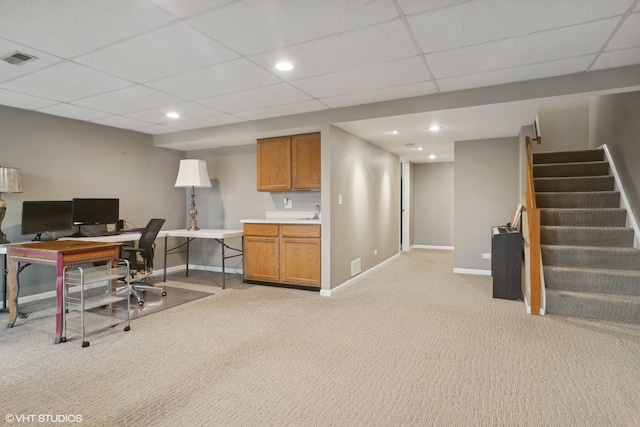 home office with light carpet, baseboards, visible vents, and a drop ceiling