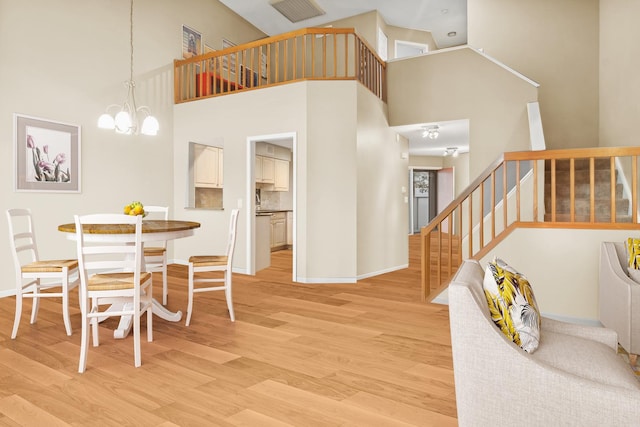 dining room with light wood-style floors, a chandelier, stairway, and baseboards