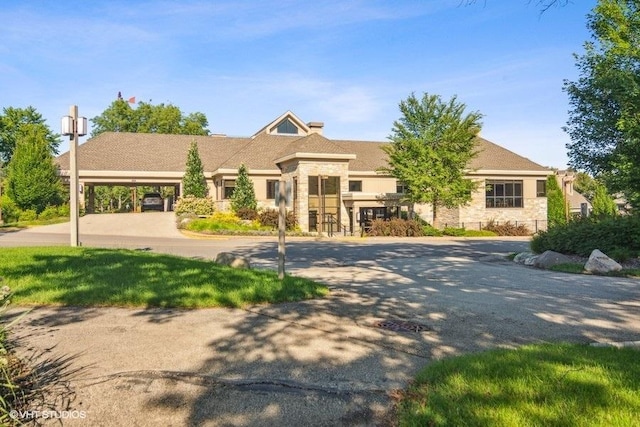 view of front of property featuring stone siding and driveway