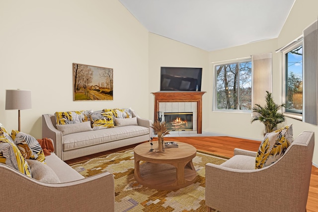 living room with lofted ceiling, a fireplace, and wood finished floors