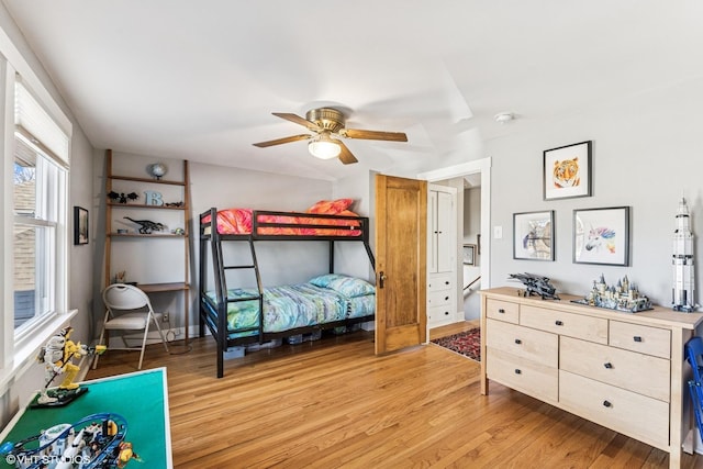 bedroom with a ceiling fan and light wood-style floors