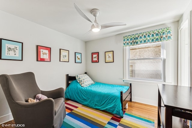 bedroom featuring wood finished floors, baseboards, and ceiling fan