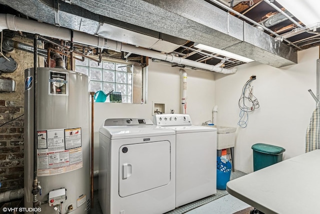 clothes washing area featuring gas water heater, independent washer and dryer, and laundry area