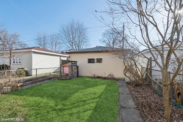 exterior space featuring an outbuilding, a lawn, and a fenced backyard