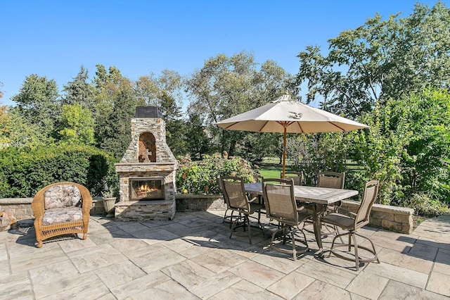 view of patio / terrace featuring outdoor dining space and an outdoor stone fireplace