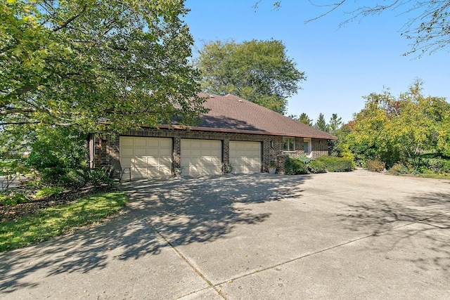 exterior space with an attached garage, driveway, and brick siding