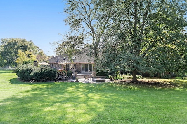 view of yard featuring an outdoor fire pit and a patio