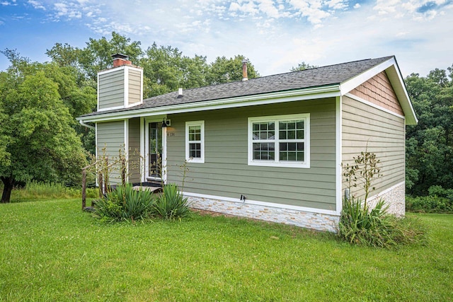 rear view of property with a yard and a chimney