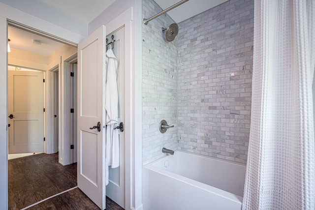 bathroom with wood finished floors and shower / tub combo with curtain