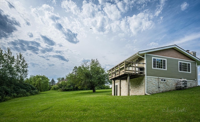 rear view of house with a lawn and a wooden deck