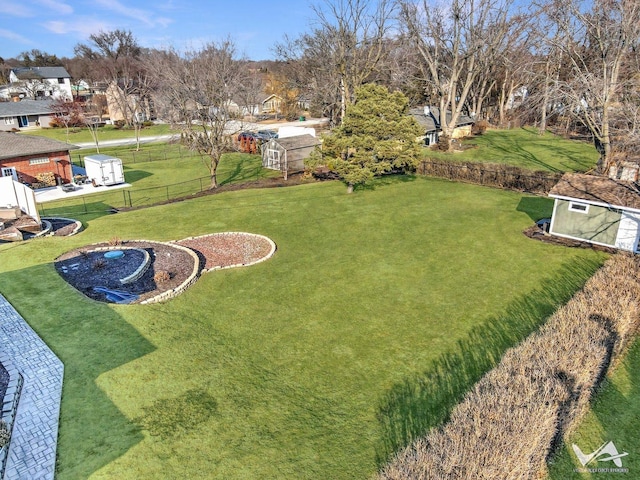 view of yard featuring fence, a storage unit, and an outdoor structure