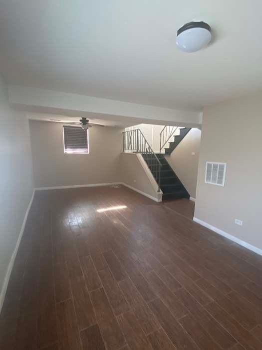 interior space with baseboards, stairs, visible vents, and dark wood-style flooring