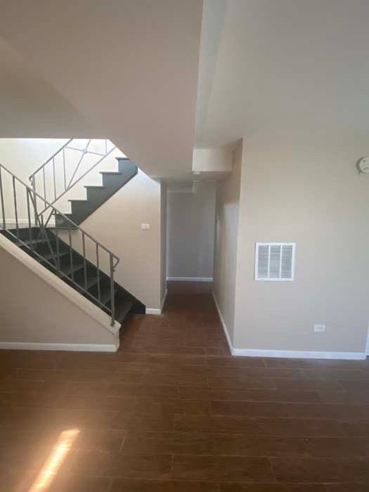 stairs with visible vents, baseboards, and wood finished floors