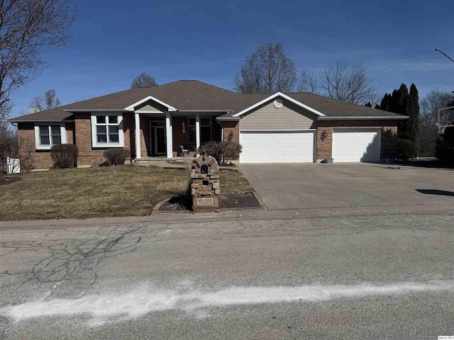 view of front of property with driveway, brick siding, a front lawn, and an attached garage