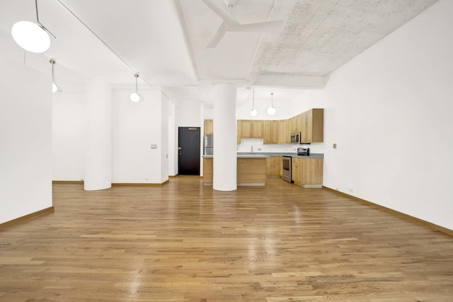 unfurnished living room with baseboards and light wood-style floors