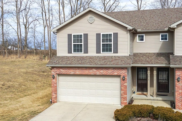 view of front of home with a garage, brick siding, driveway, and roof with shingles