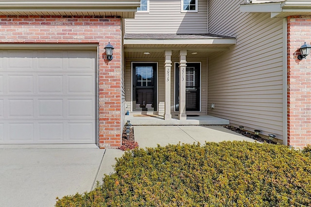 entrance to property featuring an attached garage and covered porch