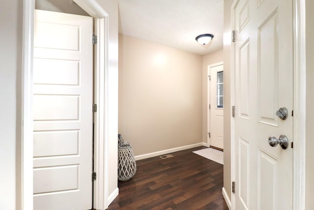 doorway to outside with dark wood-style floors and baseboards