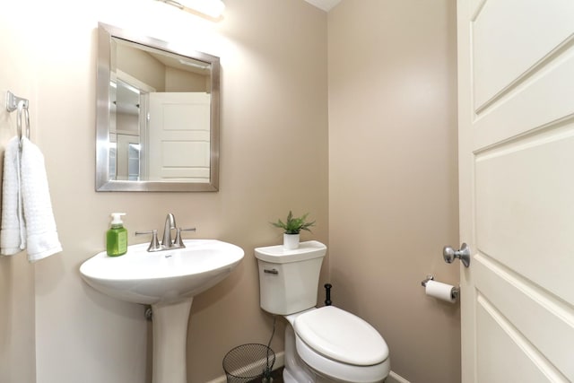 bathroom with baseboards and toilet