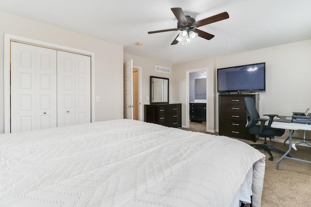 carpeted bedroom featuring ceiling fan, a closet, ensuite bath, and visible vents