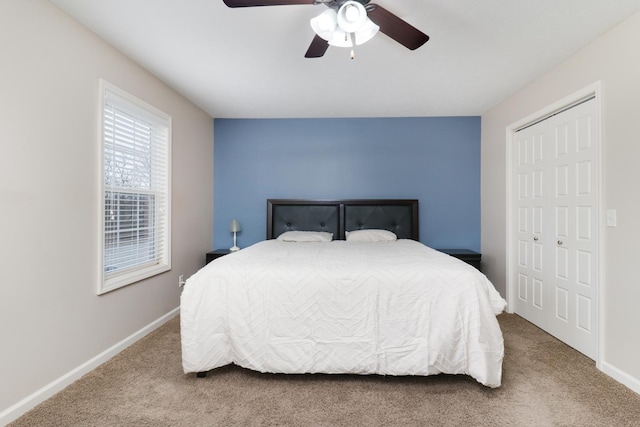 carpeted bedroom featuring ceiling fan, baseboards, and a closet