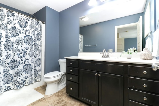 bathroom featuring toilet, curtained shower, and vanity