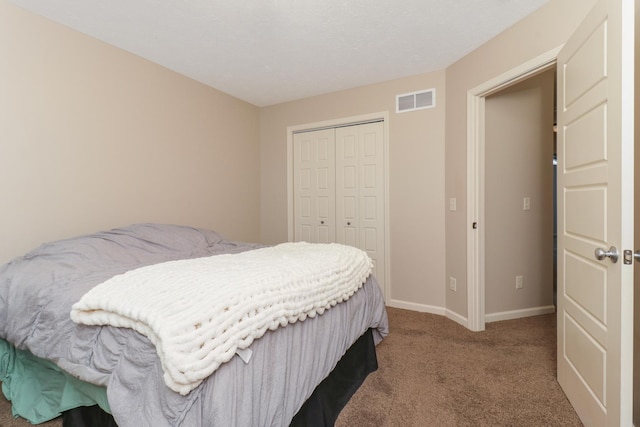 carpeted bedroom with baseboards, visible vents, and a closet