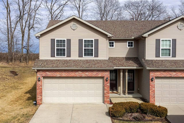 traditional-style home featuring concrete driveway, brick siding, an attached garage, and roof with shingles