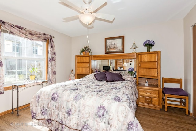 bedroom featuring a ceiling fan, baseboards, and wood finished floors