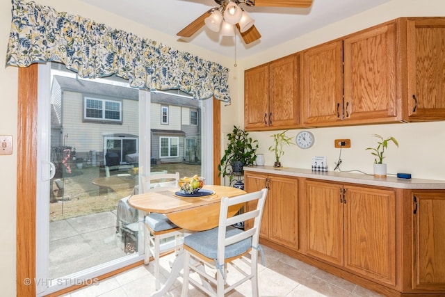 dining space with light tile patterned flooring and a ceiling fan