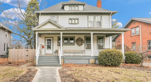 traditional style home featuring roof with shingles, a chimney, a porch, a gate, and central AC