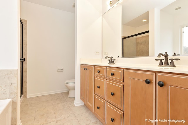 full bathroom featuring a stall shower, a sink, toilet, and double vanity