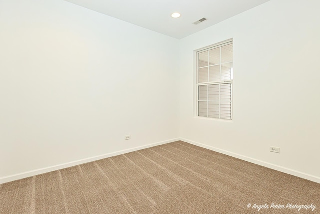 carpeted spare room featuring baseboards, visible vents, and recessed lighting