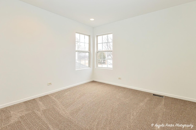 empty room with recessed lighting, carpet flooring, visible vents, and baseboards