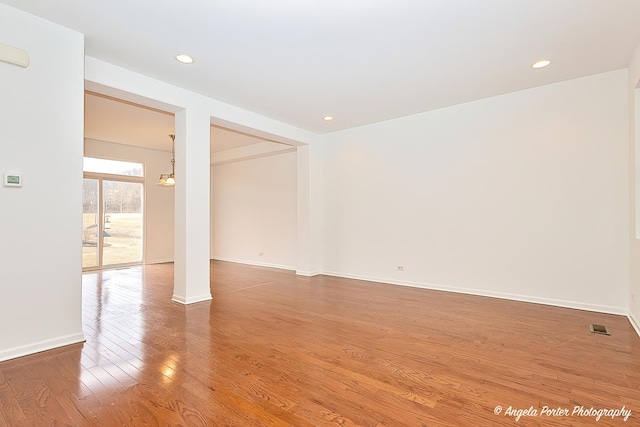 unfurnished room with baseboards, visible vents, wood finished floors, and recessed lighting