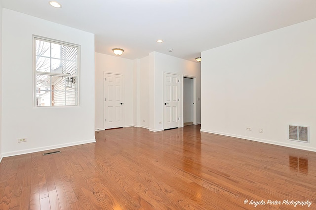 spare room featuring baseboards, visible vents, wood finished floors, and recessed lighting