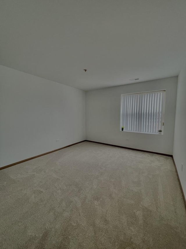 carpeted empty room featuring baseboards