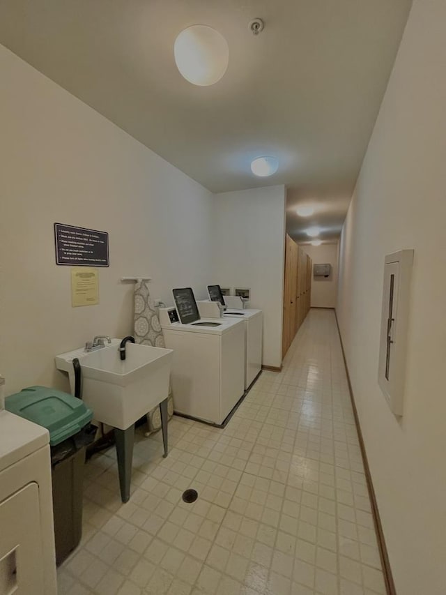 shared laundry area with electric panel, baseboards, and separate washer and dryer