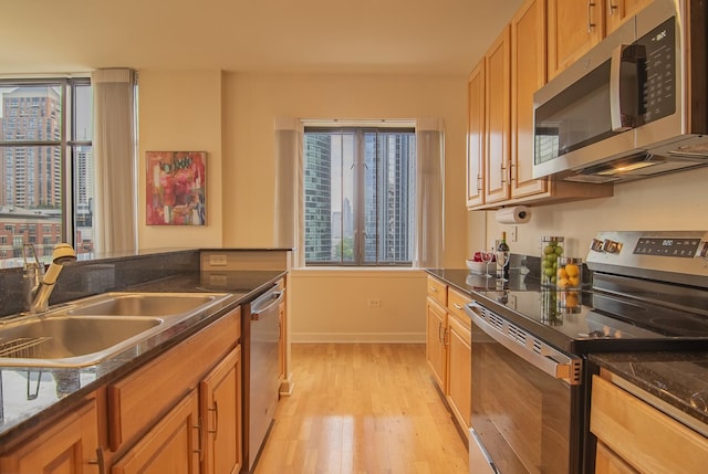 1322 S Prairie Ave Unit 1413, Chicago, IL 60605 - kitchen featuring appliances with stainless steel finishes, light wood finished floors, plenty of natural light, and dark stone counters