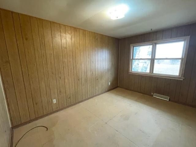 spare room featuring visible vents and wood walls